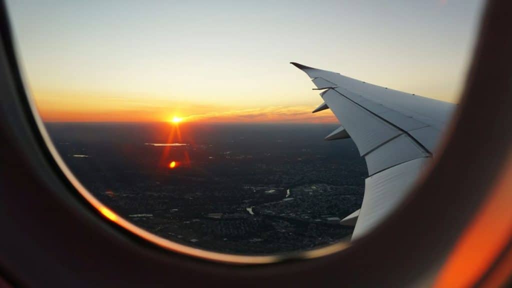 vue aérienne depuis un hublot d'avion avec coucher de soleil