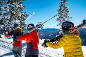 3 personnes portant leur materiel de ski